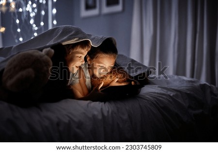 Night, bedroom and siblings with a tablet, online games and bonding with fun, happiness and relax. Children, brother or sister with technology, movies and films with development, home and bed time Royalty-Free Stock Photo #2303745809