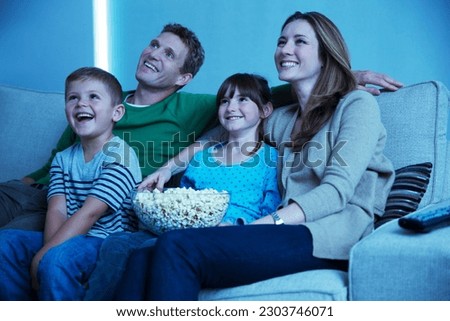 Family watching television in living room Royalty-Free Stock Photo #2303746071