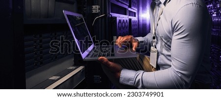 Side view of experienced IT professional collecting performance metrics from physical server Royalty-Free Stock Photo #2303749901