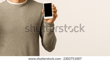 Friendly and carefree funny bearded gay man in grey sweater edit profile picture online dating app, make peace sign, showing smartphone display and smiling happily, standing white background.