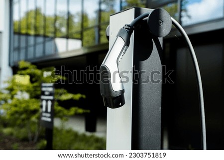 E-charching station in front of an office building Electrical car charging Royalty-Free Stock Photo #2303751819