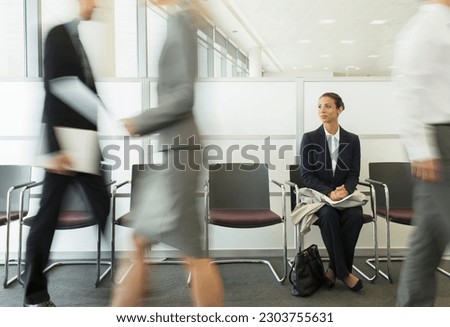 Businesswoman sitting in busy waiting area