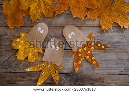 A child makes an octopus craft from autumn leaves and kraft paper. Step by step instruction Royalty-Free Stock Photo #2303761819
