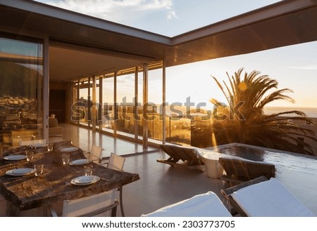 Patio overlooking swimming pool and ocean at sunset