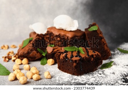 Pieces of tasty chocolate brownie with ice cream on grunge background