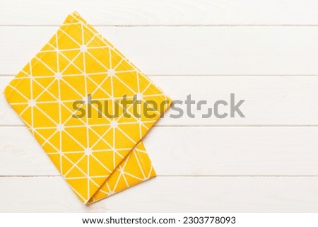 top view with yellow empty kitchen napkin isolated on table background. Folded cloth for mockup with copy space, Flat lay. Minimal style. Royalty-Free Stock Photo #2303778093