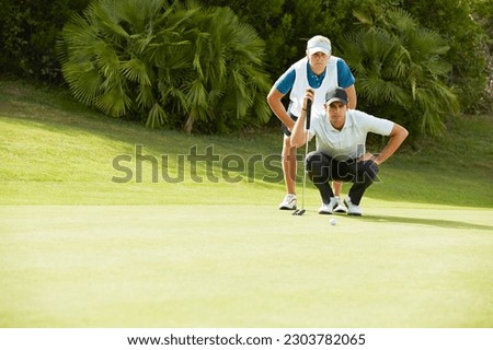 Caddy and golfer preparing to putt Royalty-Free Stock Photo #2303782065