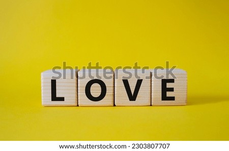Love symbol. Concept word Love on wooden cubes. Beautiful yellow background. Business and Love concept. Copy space.