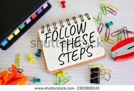 Follow these steps symbol. Concept words Follow these steps on white notebook. Beautiful wooden background. Business and Follow these steps concept. Copy space.