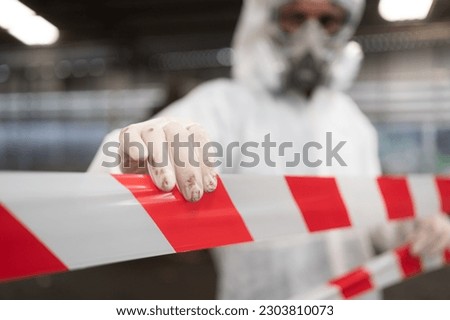 Restricted area, officials employ white and red stripes to block the area where a chemical leak is occurring. To prevent individuals from coming into contact with potentially dangerous chemicals, Royalty-Free Stock Photo #2303810073