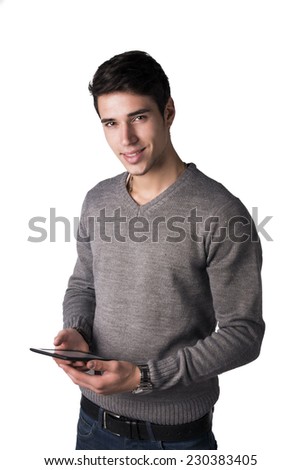 Smiling young man holding ebook reader and looking at camera, standing isolated on white background
