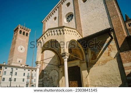 Bassano del Grappa, Italy - Entrance portico of the church of San Francesco and in the background the civic tower Royalty-Free Stock Photo #2303841145