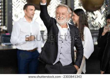 portrait of smiling senior man holding champagne glass enjoy at the birthday party. 
