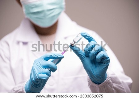 Doctor hand in blue gloves holding influenza vaccine for prevention human.Concept fight against human papilloma virus, nurse in laboratory holding a syringe with HPV vaccines for girl and woman.