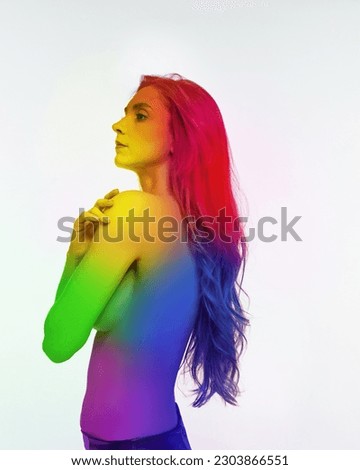 Portrait of young girl woman posing shirtless with body colored in rainbow colors against white background. Acceptance. Concept of lgbt community, support, love, human rights, pride month