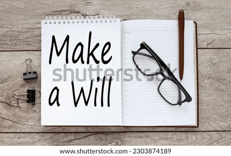 Make a will glasses on a notepad on a wooden table. text on the page