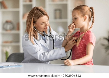Pediatrician Lady With Stethoscope Listening Lungs Of Coughing Little Girl During Checkup, Professional Pediatrist Doctor Woman Checking Health Condition Of Sick Female Child, Closeup Shot Royalty-Free Stock Photo #2303906513