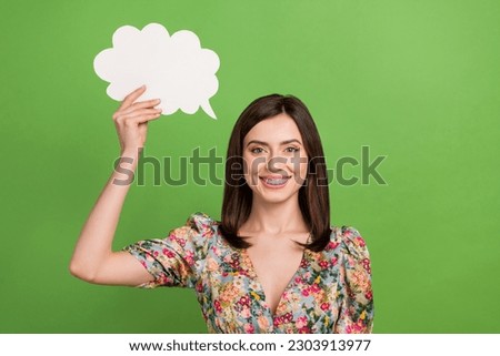 Photo of young girl wear springtime blouse flowers print hold paper bubble cloud empty space opinion isolated on green color background