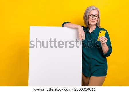 Photo of promoter aged lady search cell gadget enjoying promotion empty card paper wall isolated on bright color background