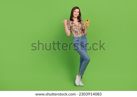 Full body photo of young brown hair lady customer recommend watch her video on phone point finger mockup isolated over green background