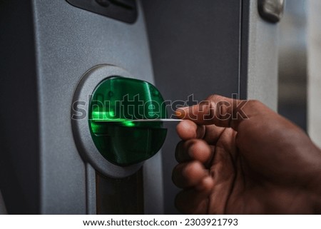 Close up of man's hand inserting a credit card in an ATM to deposit cash in the bank account Royalty-Free Stock Photo #2303921793