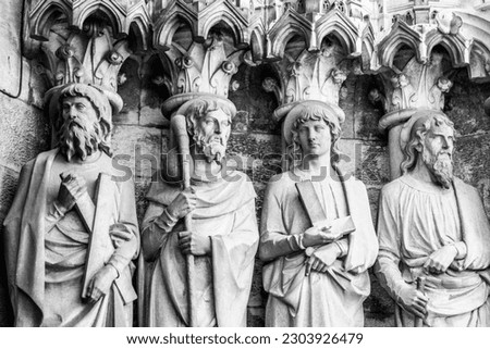 Sculptural images of the Holy Apostles on the wall of the facade of Saint Fin Barre's Cathedral in Cork, Ireland. The Apostles Andrew, James major, Thomas, Matthias. Black and white image. Monochrome. Royalty-Free Stock Photo #2303926479