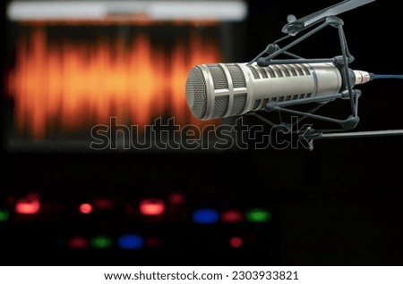 Professional microphone, sound mixer and wave form on the screen