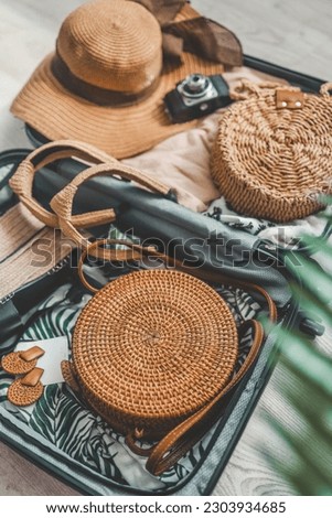 Close up of travel bag, hat and sunglasses on wooden background. Royalty-Free Stock Photo #2303934685