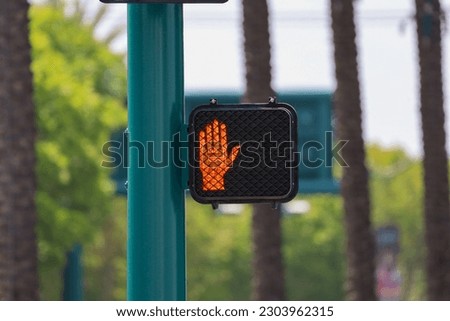 A red upraised hand light which symbolizes Don't Walk, Stop or Wait.