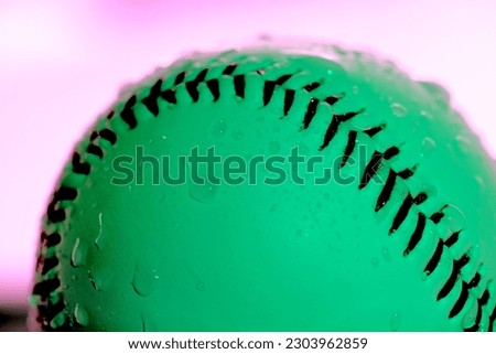 Glow of wet baseball with copy space for rain game concept and creative purple and green lighting background.