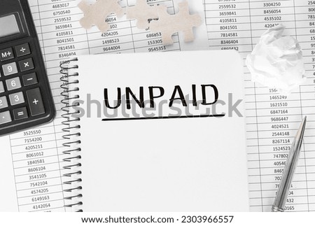 Notebook with word unpaid on financial background Royalty-Free Stock Photo #2303966557