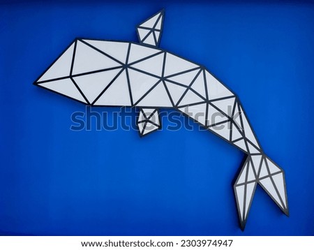 Decorative panel in the form of a whale on a blue wall