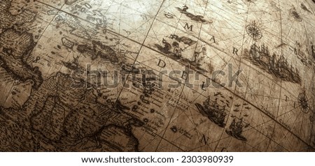 Fragment of an ancient globe. Old globe map background. A concept on the topic of sea voyages, discoveries, pirates, sailors, geography, travel and history.   Royalty-Free Stock Photo #2303980939