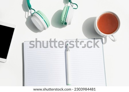 phone, head phones, note and stationery isoalted over background, business or educational tools, wok from home concept. High quality photo