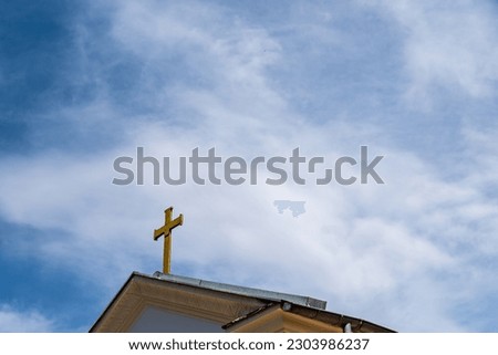 Christian cross on Church Roof. Church building roof with holy cross. blue sky background with clouds on a sunny day
