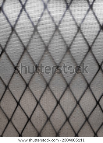 An image of a blurry door with a trellis silhouette shadow