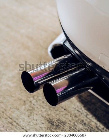Chrome exhaust tips on a white car