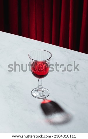 Lambrusco glass on a marble table with a red curtained background Royalty-Free Stock Photo #2304010111