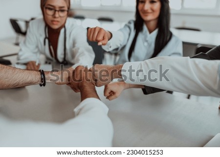 A group of doctors and a medical nurse join their hands together on a table, showcasing the unwavering teamwork and solidarity that drives their collective efforts in the healthcare field Royalty-Free Stock Photo #2304015253