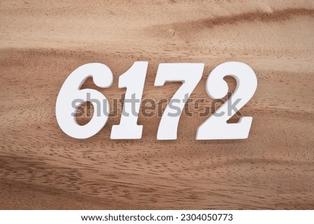 White number 6172 on a brown and light brown wooden background.