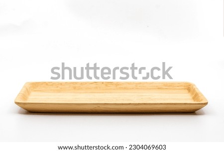 Small serving wooden tray with empty space for bakery or other snacks, side view, image on white background, the clipping path around the wooden tray in the file. Royalty-Free Stock Photo #2304069603