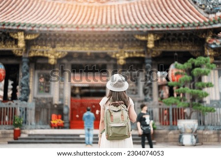woman traveler visiting in Taiwan, Tourist with hat sightseeing in Longshan Temple, Chinese folk religious temple in Wanhua District, Taipei City. landmark and popular. Travel and Vacation concept Royalty-Free Stock Photo #2304074053