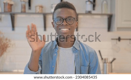 Portrait of Young African Man Waving at Camera