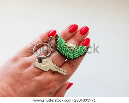 Colorful keychain lies on a woman's palm. Bead colorful key chain in hand