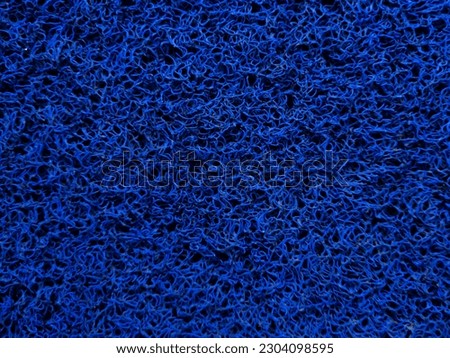 The blue background is made of noodle-shaped plastic fibers that look strong and textured