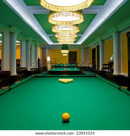 Yellow sphere on a billiard table in a night club