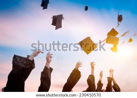 graduates throwing graduation hats in the air. Royalty-Free Stock Photo #230410570