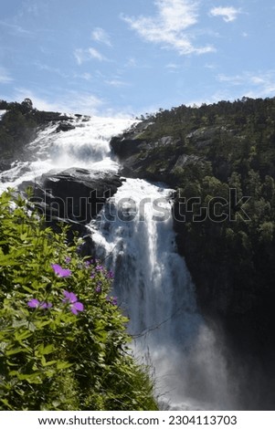 a wide waterfall in the mountains of Norway