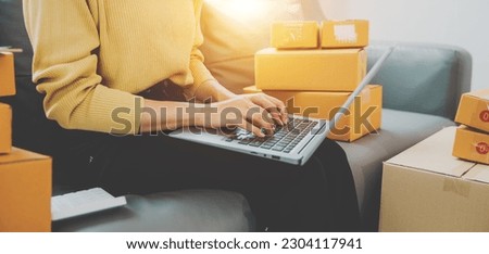 Starting a Small Business Entrepreneur Close up of independent asian woman using laptop with box Cheerful successful online marketing packaging box and send SME concept. Royalty-Free Stock Photo #2304117941