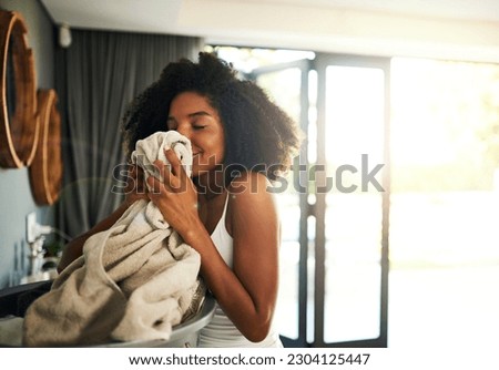 Laundry smell, african woman and cleaning chores with happiness and calm in home. Smile, fresh clothes and lens flare with washing of a black female person in a house feeling relax in the morning Royalty-Free Stock Photo #2304125447